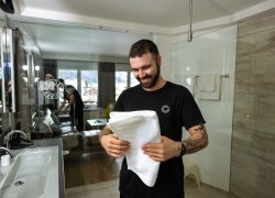 Ein Mann in Haubers Kleidung bereitet eines der Themenzimmer für die Anreise neuer Gäste in Haubers Wellnesshotel vor.