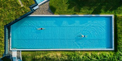 Im Sportpool und im Relaxpool von Haubers Wellnesshotel im Allgäu genießen Gäste im Sommer das kühle Wasser.