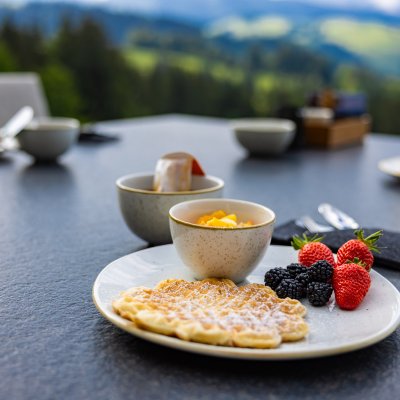 Süße Waffeln und frisches Obst serviert Haubers Naturresort beim Bergfrühstück auf 950 Metern Höhe.