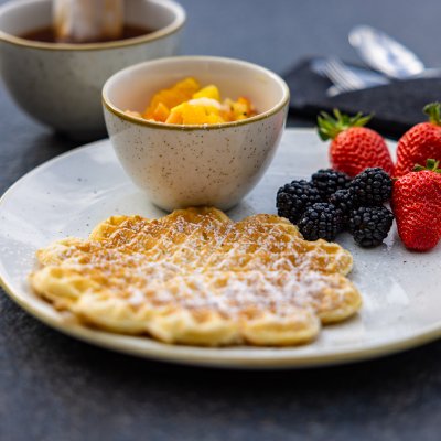 Duftende Waffeln, frische Erdbeeren, Brombeeren und Obstsalat stehen auf dem Frühstückstisch von Haubers Naturresort.