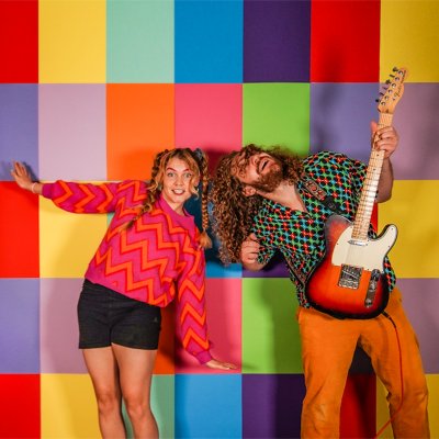 Die Band Fruit Sharks spielt bei Kultur am Schwalbennest für Haubers Gäste. Marlene und Oli von der Band Fruit Sharks posieren vor einer rustikalen Holzwand, fotografiert von Simon Kübler.