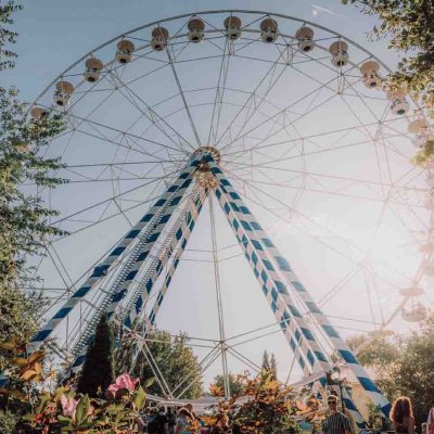 Besucher stehen vor dem Sonne beschienenen Riesenrad  © Allgäu Skyline Park.