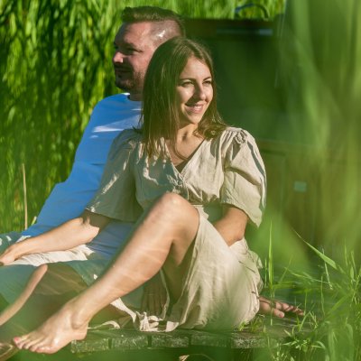 Pärchen am Natursee Mann und Frau genießen Zweisamkeit am Steg des Natursees zwischen Schilfgräsern