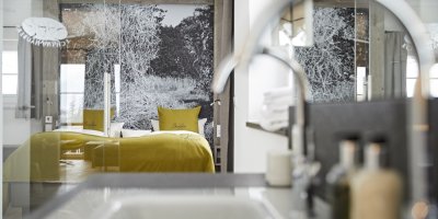 Das Doppelbett des Themenzimmers Bergheu gesehen vom Badezimmer aus.