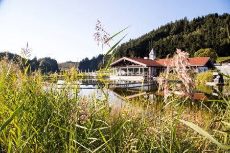 Der Haubers Natursee liegt direkt vor dem Wellnessbereich des Erwachsenenhotels, Haubers Naturresort im Allgäu.