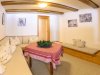 Gemütlicher Raum mit Tisch und Sitzecke In einem Raum steht ein Tisch mit einer Tischdecke. Es gibt Sitzflächen und Bilder an den Wänden.