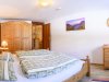 Schlafzimmer mit Holzmöbeln und einem Gemälde In einem Schlafzimmer stehen zwei Betten mit Bettwäsche. Ein Schrank und eine Kommode sind sichtbar. Ein Gemälde hängt an der Wand.