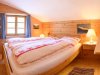 Ein Schlafzimmer in einem Holzhaus Das Schlafzimmer hat ein Doppelbett, Fenster und Lampen. Es ist hell und gemütlich.