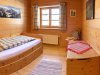 Rustikales Zimmer mit Holzinterieur und Fenster Im Raum steht ein Bett mit einer Decke. Es gibt einen Tisch und einen Fenster mit Aussicht auf die Berge.