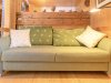 Gemütliches Sofa in einer Holzwohnung Das Sofa steht in einem Raum mit Holzverkleidung. Kissen liegen auf dem Sofa. Es ist hell und freundlich.