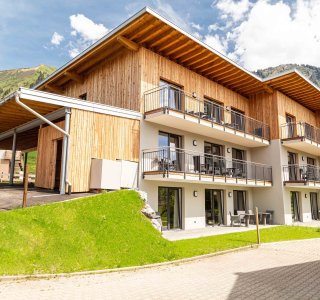 Parkmöglichkeiten und Balkone am Haus Fellhorn an einem Sommertag fotografiert - im Hintergrund das Fellhorn.