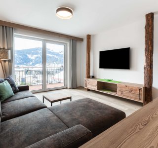 Großes Sofa in einer hellen Ferienwohnung mit Blick aus dem Fenster.