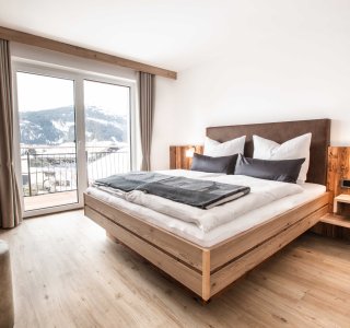 Ansicht vom Schlafzimmer mit Doppelbett und Ausgang auf den Balkon.