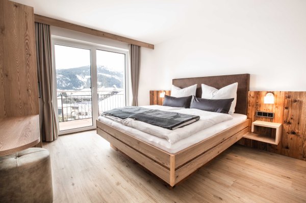 Ansicht vom Schlafzimmer mit Doppelbett und Ausgang auf den Balkon.