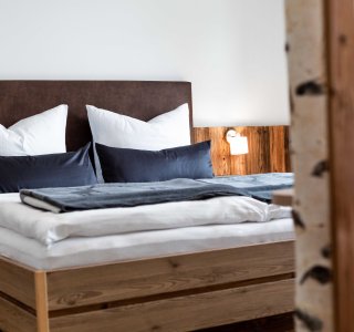 Doppelbett in einer Ferienwohnung mit Nachttischlampe.