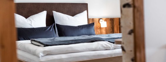 Doppelbett in einer Ferienwohnung mit Nachttischlampe.