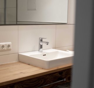 Badezimmeransicht mit Waschbecken und Spiegel.