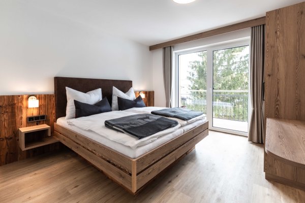 Ansicht vom Schlafzimmer mit Doppelbett und Ausgang auf den Balkon.