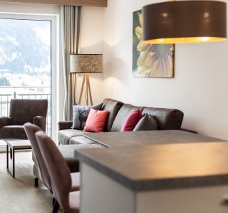 Bild vom Wohnzimmer mit Sofa und Balkontüre.