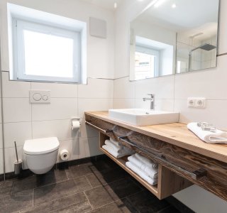 Helles Badezimmer mit Dusche, WC und Waschbecken.