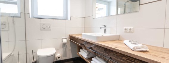 Helles Badezimmer mit Dusche, WC und Waschbecken.