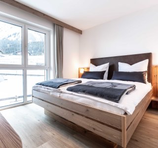 Schlafzimmer mit Doppelbett und Blick aus dem Fenster.