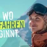 Eine Frau genießt die Aussicht auf die Berge und hält einen Becher. Es ist ein klarer Tag ideal zum Skifahren.