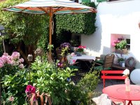 Bunte Gartenszene mit Sonnenschirm und Blumen