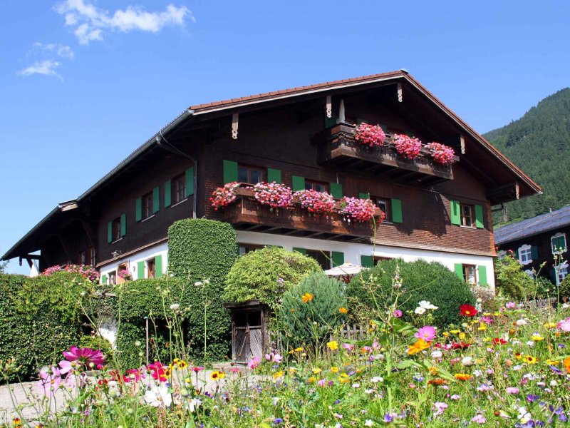 Bunt blühendes Haus in den Bergen