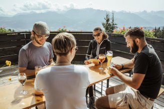 Entspannte Wanderpause auf der Hörnerhaus-Sonnenterasse mit Kartenspielen und kühlen Getränken.