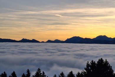 Während das Nebelmeer im Tal die Sicht auf die Berge versperrt, geht am Hörnerhaus schon die Sonne auf.