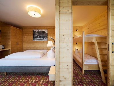 In der Familiensuite gibt es ein kleines Kinderzimmer mit Türe, damit die Kinder selig träumen, während die Eltern noch ein Glas Wein oder ein gutes Gespräch genießen.
