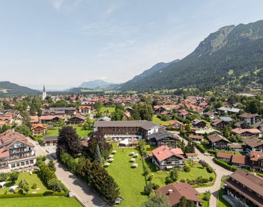 Drohnenperspektive auf das Hotel Exquisit mit Bergpanorama