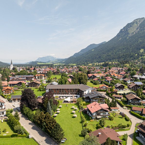 Drohnenperspektive auf das Hotel Exquisit mit Bergpanorama