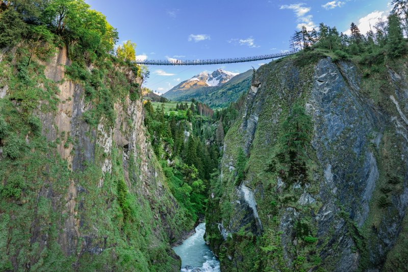 Die Hängebrücke am Iseltrail bei Virgen in Osttirol. Der Iseltrail führt entlang der Isel durch das ursprüngliche Virgental im Nationalpark Hohe Tauern und ist ein besonderes Erlebnis für Wanderer. Von Prägraten am Großvenediger und dem Hotel HEIMAT ist die Wanderregion rund um die Isel bequem erreichbar.