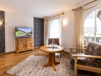 Wohnzimmer mit Fernseher und zwei Stühlen