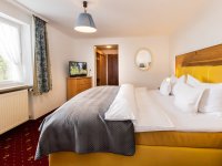 Hell erleuchtetes Zimmer mit großem Bett