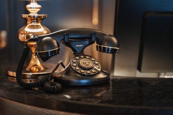 Stilvolle Grandhotel-Details im Hotel Mohren Oberstdorf: Das elegante Retro-Telefon an der Rezeption erinnert an die Tradition und Geschichte des Hauses. Hier verbindet sich klassisches Ambiente mit moderner Gastfreundschaft – für einen Urlaub im Allgäu mit besonderem Flair.