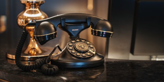 Stilvolle Grandhotel-Details im Hotel Mohren Oberstdorf: Das elegante Retro-Telefon an der Rezeption erinnert an die Tradition und Geschichte des Hauses. Hier verbindet sich klassisches Ambiente mit moderner Gastfreundschaft – für einen Urlaub im Allgäu mit besonderem Flair.