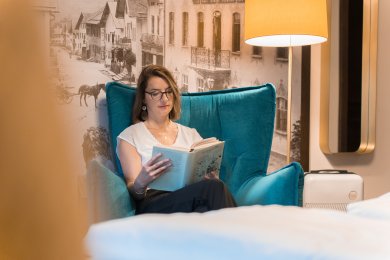 Wohlfühlatmosphäre im Hotel Mohren in Oberstdorf: In einem gemütlichen Sessel genießen Gäste entspannte Lesestunden und erholen sich vom Alltag. Ideal für eine Auszeit im Allgäu mit Ruhe, Komfort und Stil.