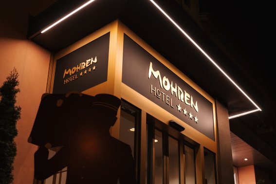 Außenansicht des Hotel Mohren in Oberstdorf Der beleuchtete Eingangsbereich des Hotel Mohren Oberstdorf präsentiert sich bei Nacht modern und einladend. Die klare Architektur, das markante Hotellogo und die stilvolle Außenbeleuchtung unterstreichen den hochwertigen Charakter des Hotels im Zentrum von Oberstdorf.