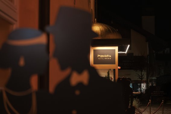 Die Außenansicht des Hotel Mohren Oberstdorf zeigt liebevoll gestaltete Details, die die lange Geschichte des Hauses widerspiegeln. Die stilisierte Silhouette, die klassische Beschilderung und die warme Beleuchtung verbinden Tradition und Eleganz und verleihen dem traditionsreichen Hotel im Ortskern von Oberstdorf seinen unverwechselbaren Charakter.
