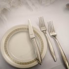 Stilvoll eingedeckte Terasse mit weißen Tischdecken, eleganten Stoffservietten und edlen Kandelabern.