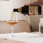 Jemand schenkt ein Glas Bier ein und auf dem Tisch steht verschiedene Deko.