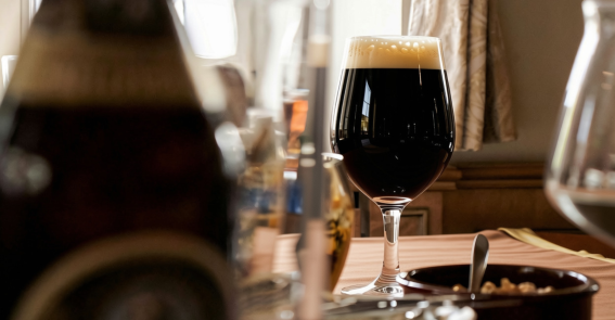 Biertulpe Auf einem Tisch steht ein Biertulpe mit dunklem Craft-Bier.