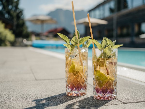 Erfrischung im Sommer im Wellnessurlaub in Allgäu / Sommerurlaub mit Wellnessauszeit Im Hotel Oberstdorf warten besondere Wellnessmomente auf Sie. Wie wäre es mit einer leckeren Erfrischung am Pool, während Sie Ihre Wellnessauszeit in den Allgäuer Bergen genießen.