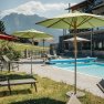Außenpool mit Bergblick im Hotel Oberstdorf im Allgäu Beheizter Außenpool des Hotel Oberstdorf mit Sonnenliegen und Blick auf die Allgäuer Berge – entspannte Wellnessmomente unter freiem Himmel.