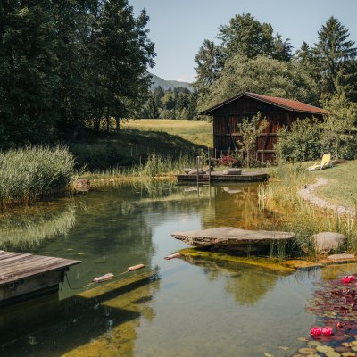 Im Hotel Oberstdorf erwartet Sie ein ganz besonderes Highlight - ein eigener Naturbadesee im Wellnessbereich.