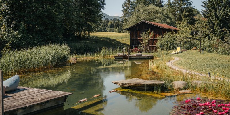 Im Hotel Oberstdorf erwartet Sie ein ganz besonderes Highlight - ein eigener Naturbadesee im Wellnessbereich.