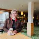 Hotel manager Magdalena stands with a coffee at a table in the Hotel Oberstdorf